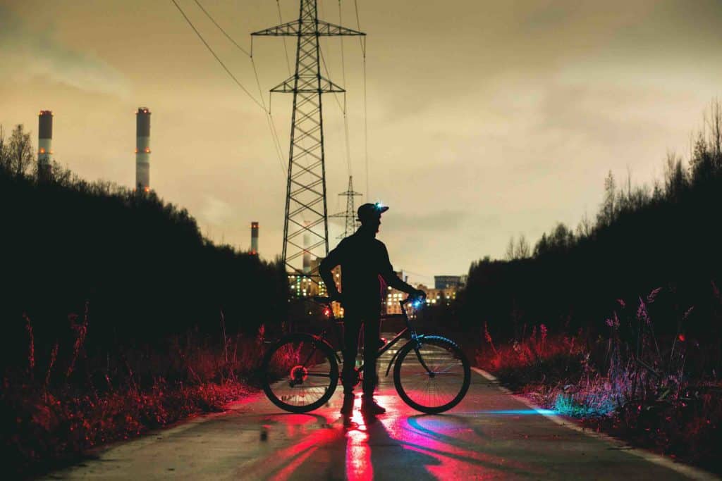 Cyclist with lights on his head and bicycle at night. Bicycle Helmet Laws by US State