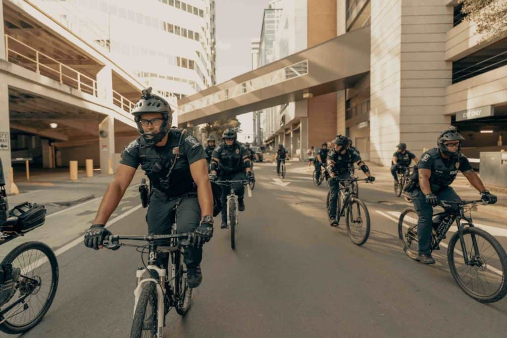 Police officers wearing helmets while cycling through the city. Bicycle Helmet Laws by US States