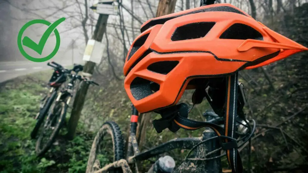 Photo of two mountain bikes and an orange mountain bike helmet.