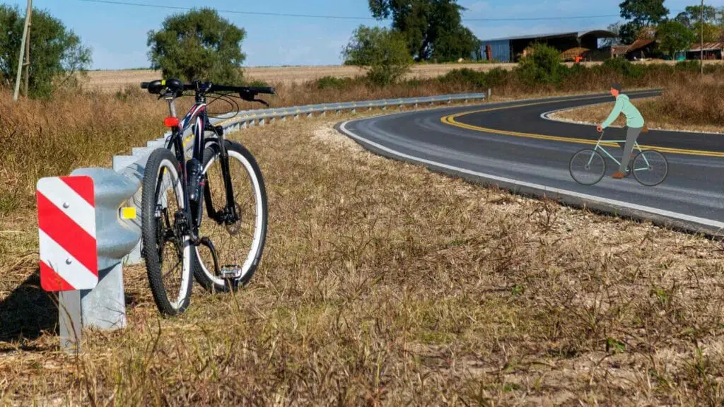A mountain bike stoped near a road.