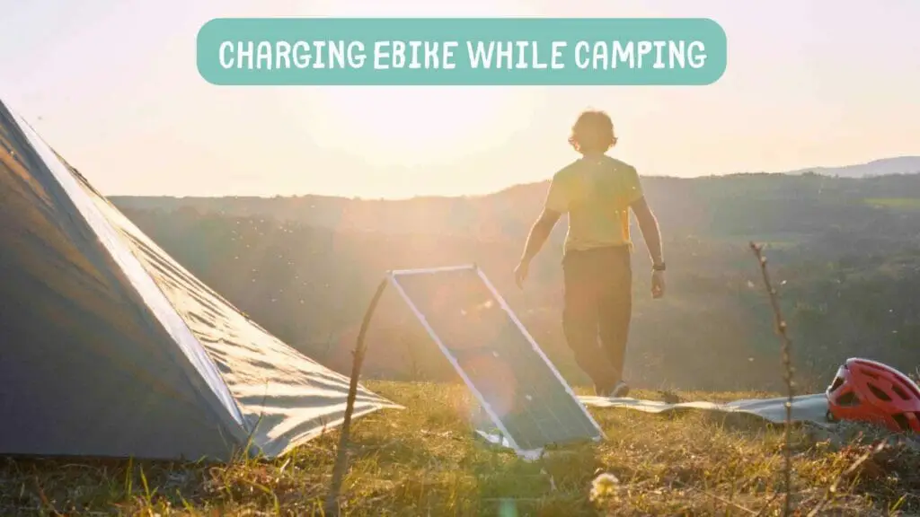 Photo of a man camping and charging his ebike with solar panels. Charging Ebike While Camping.