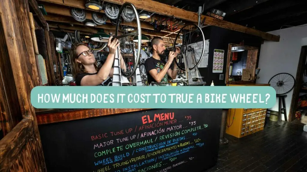 Photo of two bicycle mechanics truing bike wheels. How Much Does It Cost To True a Bike Wheel?